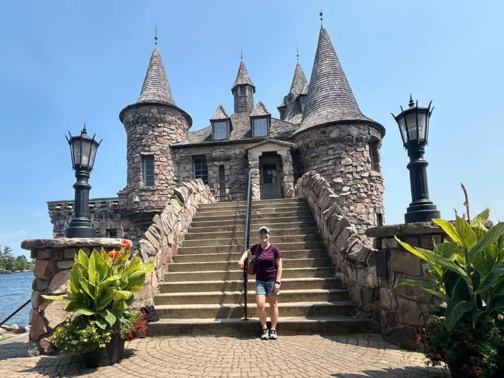 A woman standing in front of a mini castle in the Thousand Islands NY